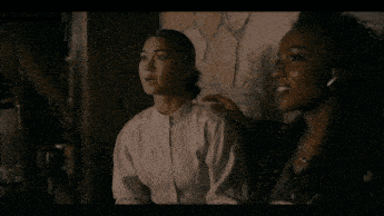 two women are sitting next to each other and one has her hand on the other shoulder