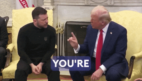 two men are sitting on a couch with a sign that says you 're on it