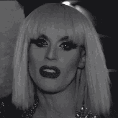 a black and white photo of a woman wearing a wig