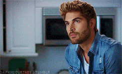 a man with a beard wearing a denim shirt