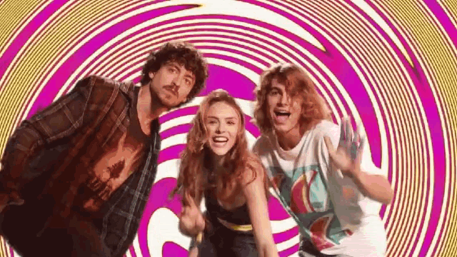 a man , a woman and a boy are standing in front of a purple and yellow swirl .