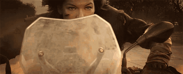 a woman riding a motorcycle with a clear windshield covering her face