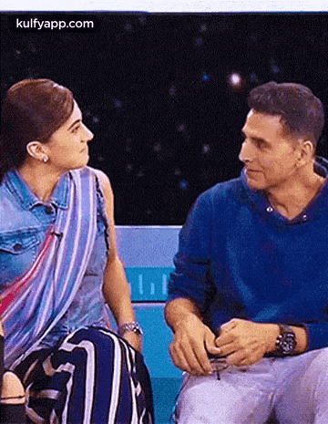 a man and a woman are sitting next to each other on a bench .