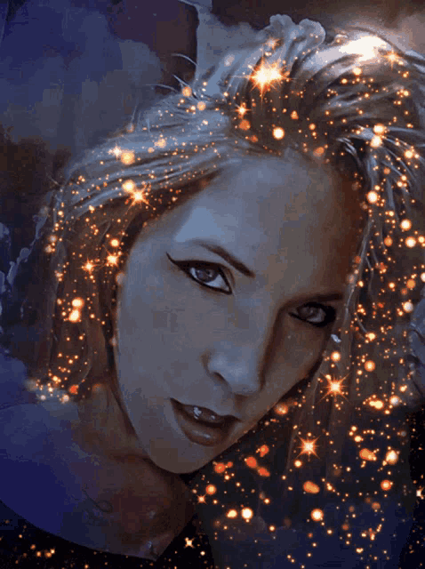 a close up of a woman 's face with sparkles in her hair