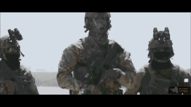 a group of soldiers are standing next to each other holding guns in the desert .