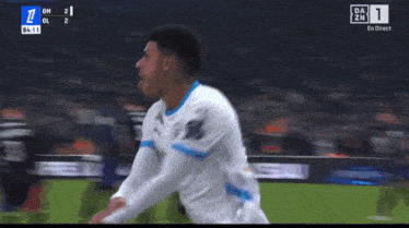 a soccer player celebrates a goal during a game on a television screen