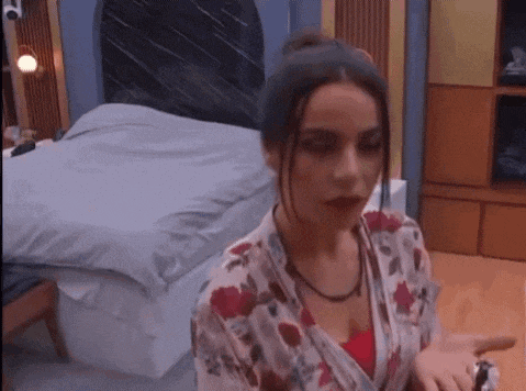 a woman is standing in front of a bed in a room .