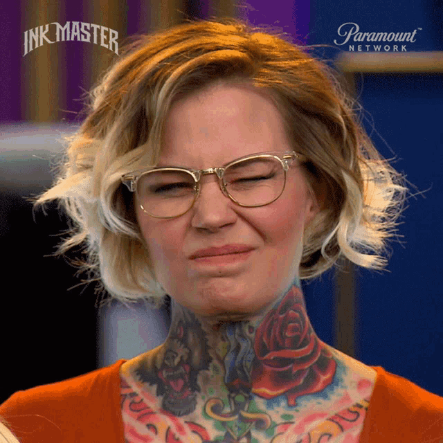 a woman with glasses and a tattoo on her neck is making a funny face in front of an ad for paramount network