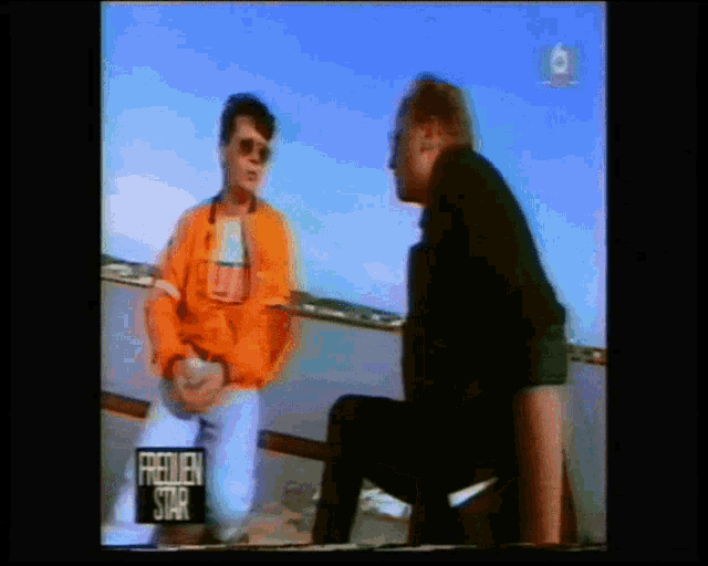 two men are having a conversation in front of a sign that says frauen star