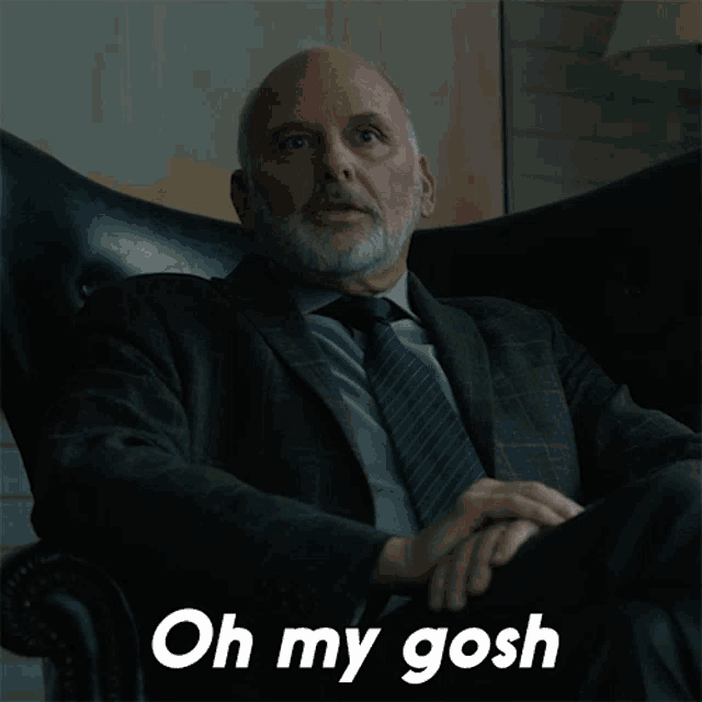 a man in a suit and tie is sitting in a chair with his eyes closed and the words oh my gosh below him