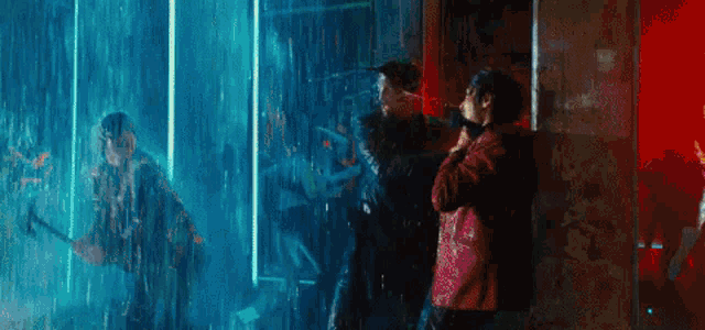 a man is holding a hammer in the rain while another man stands behind him .