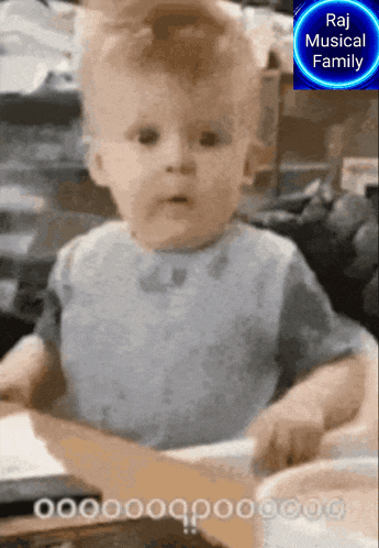 a baby is playing a musical instrument with a raj musical family logo behind it