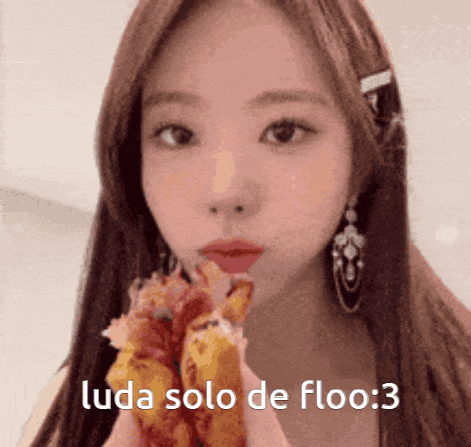 a girl with long hair is eating a sandwich with the words " luda solo de floo : 3 " written below her