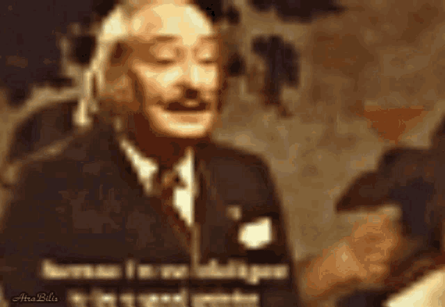 a man in a suit and tie is talking to another man in a dark room .
