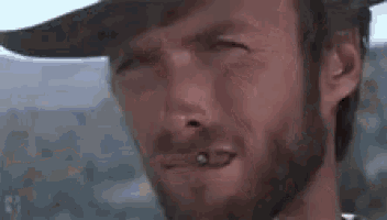 a man with a beard is wearing a cowboy hat and making a face .