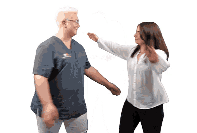 a woman in a blue scrub top is giving a high five to a woman in a white shirt