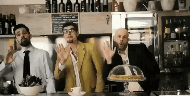 three men are standing in front of a sign that says gin mid on it