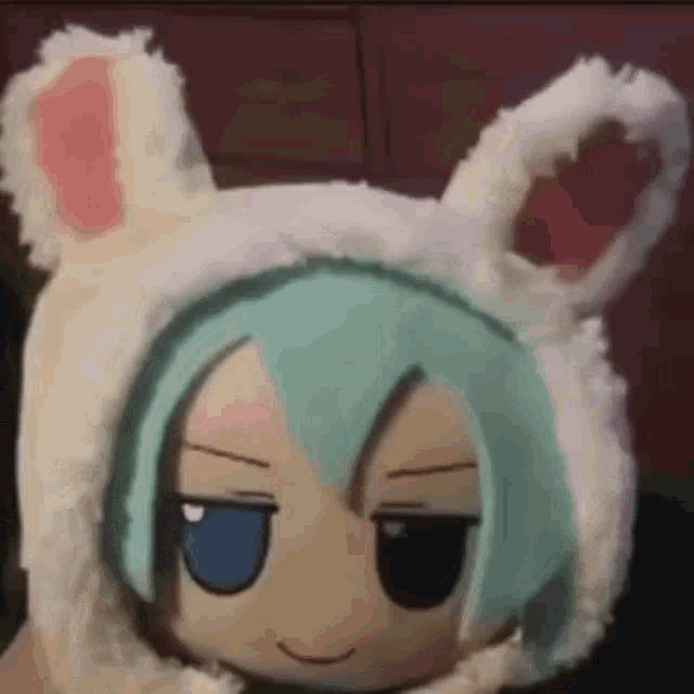a stuffed animal with bunny ears and blue eyes is wearing a white hat .