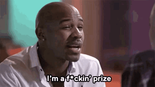 a man in a white shirt is talking and says i 'm a f * cking prize