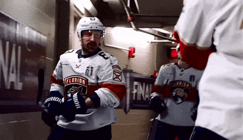 a hockey player in a florida jersey stands in a hallway
