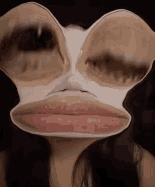 a close up of a woman 's face with a mask on it that looks like a frog 's face .