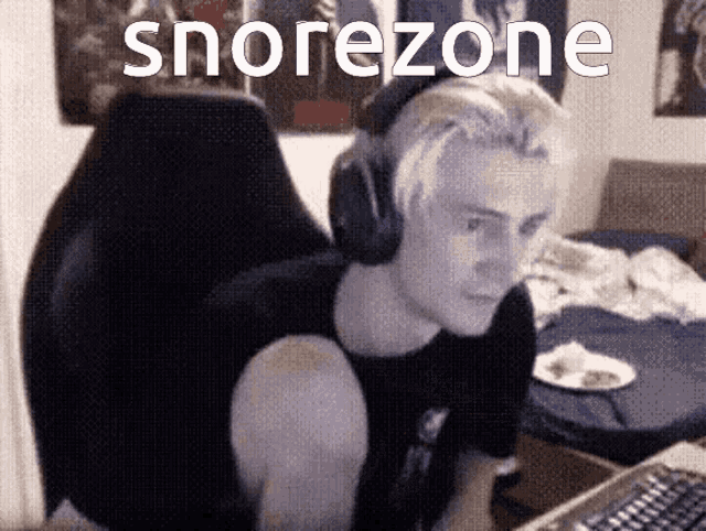 a man wearing headphones is sitting in front of a computer with the word snorezone written on the screen