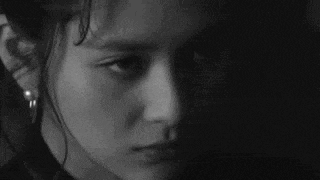 a black and white photo of a little girl 's face .