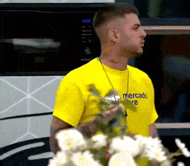 a man wearing a yellow mercado libre t-shirt