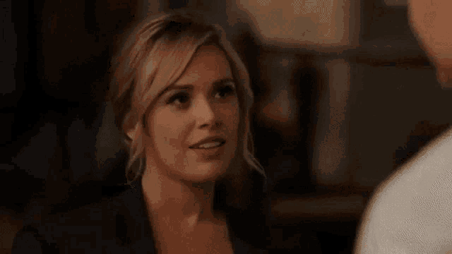 a woman in a suit is talking to a man in a restaurant .