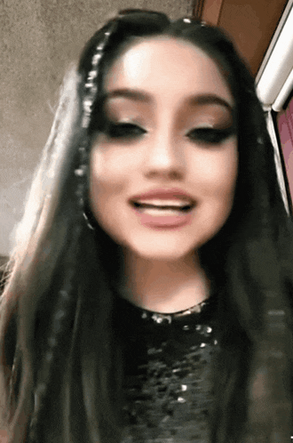 a close up of a woman 's face with long hair and makeup