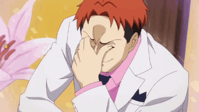 a man with red hair and a white jacket is covering his nose with his hand