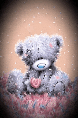 a teddy bear is sitting on a pile of flowers with a heart in its paws .