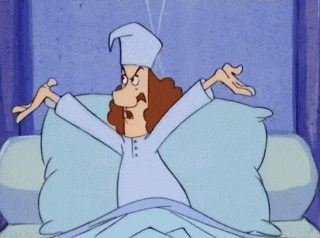 a cartoon character is laying in bed with his arms up