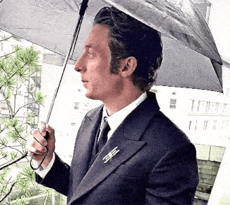 a man in a suit and tie is holding an umbrella .