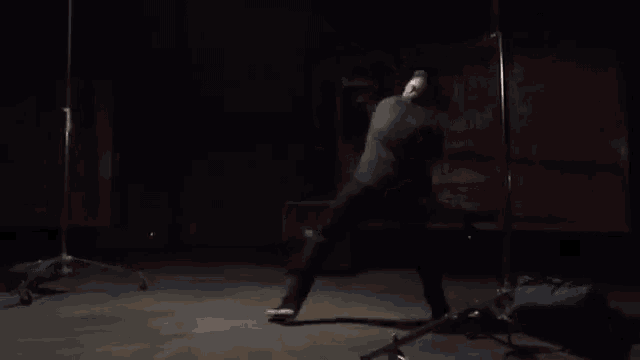 a man is doing a trick on a stage in the dark .