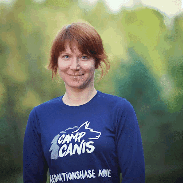 a woman wearing a blue shirt with camp canis written on it