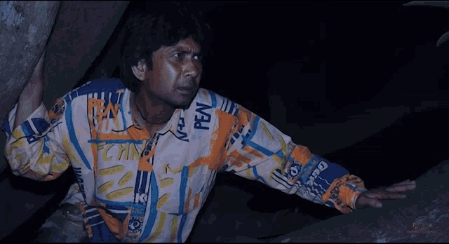 a man wearing a colorful shirt that says pen on it