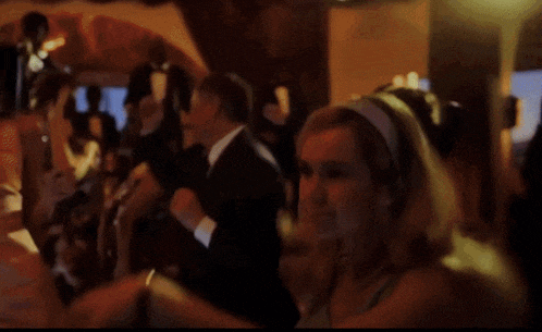 a woman in a blue dress is dancing with a man