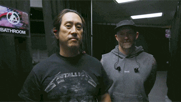 two men are standing next to each other and one of them is wearing a metallica shirt