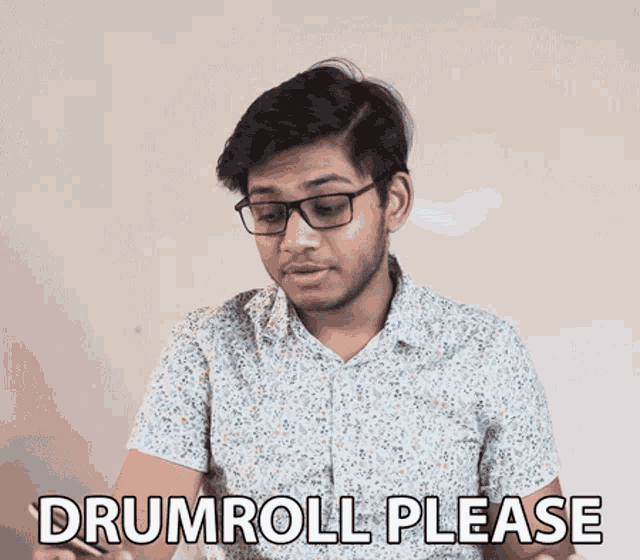 a man wearing glasses says drumroll please