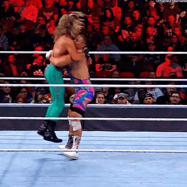two wrestlers in a wrestling ring with a crowd behind them and the words the next thing on the bottom right