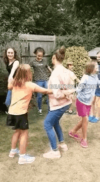 a group of people are dancing in a circle in a yard .