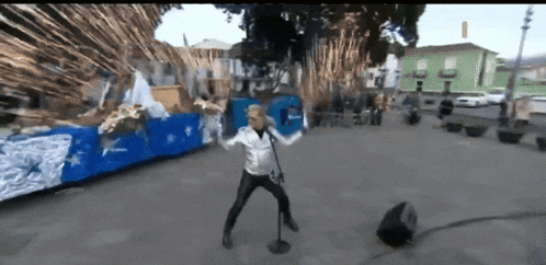 a man singing into a microphone in front of a blue and white float that says peace