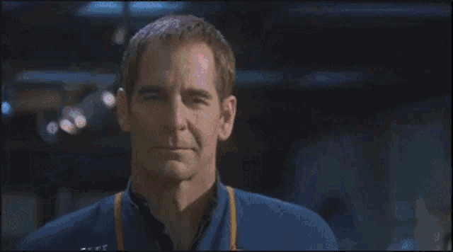 a blurry picture of a man in a blue shirt with a yellow stripe