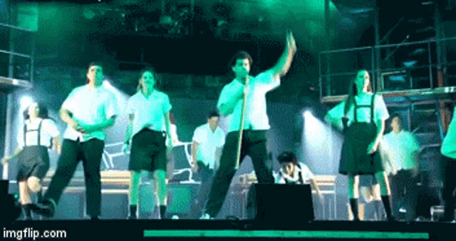 a group of people are dancing on a stage and the website imgflip.com is on the bottom