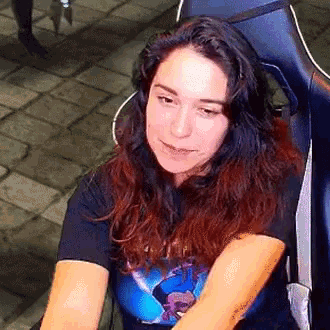 a woman is sitting in a chair wearing a black t-shirt with a picture of a dolphin on it