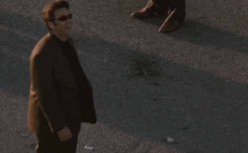 a man in a suit and sunglasses says " oookaaay mothaf ** ka "
