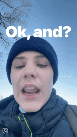 a man wearing a blue beanie and a black jacket says ok and
