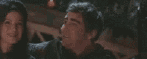 a man and a woman are standing next to each other and the man is smiling .
