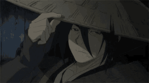 a man with long hair is wearing a hat and covering his face .